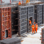 Slab formwork rental on construction site showing stacked formwork panels and workers installing